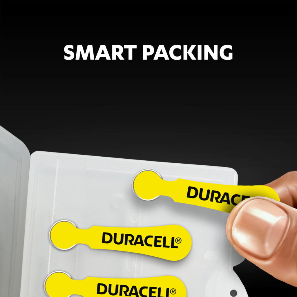 Fingers holding the hearing aids batteries from a package